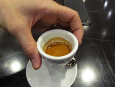 An espresso cup and saucer in hand at Paul Bassett Coffe Shibuya Tokyo Japan
